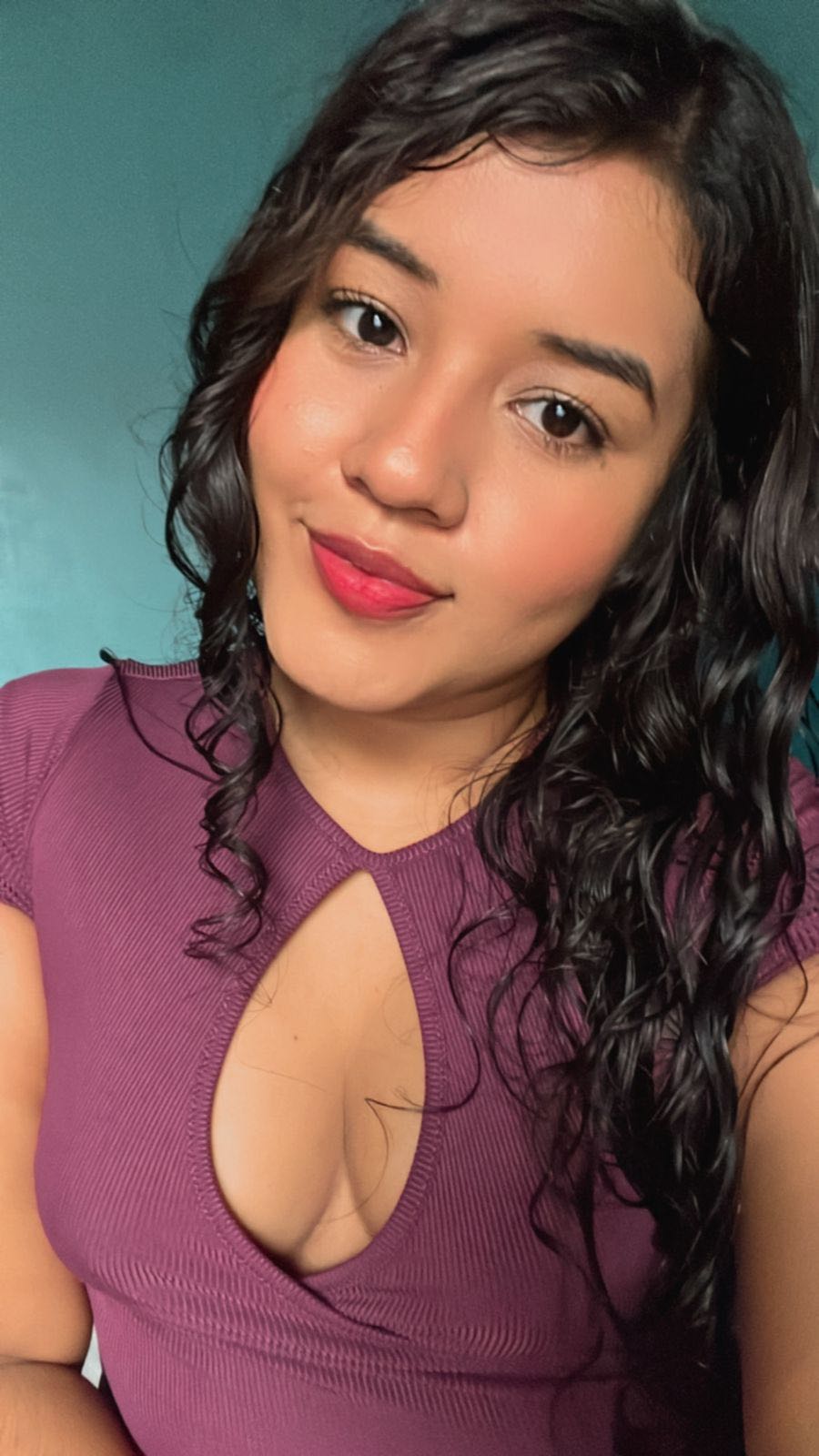 Woman in a magenta top facing soft front light during a video call