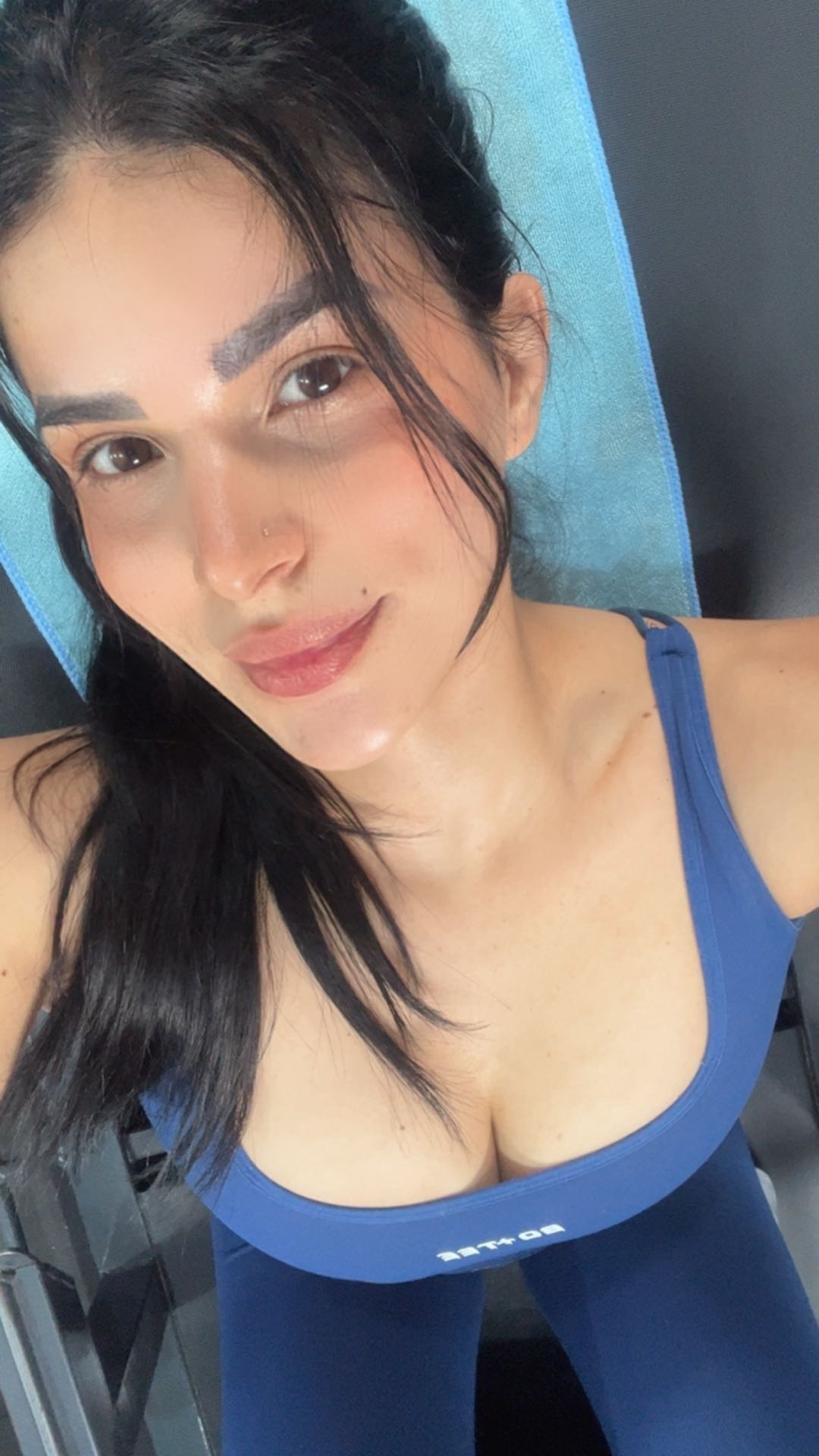 Woman in a blue top with head-and-shoulders framing that fills a video chat frame